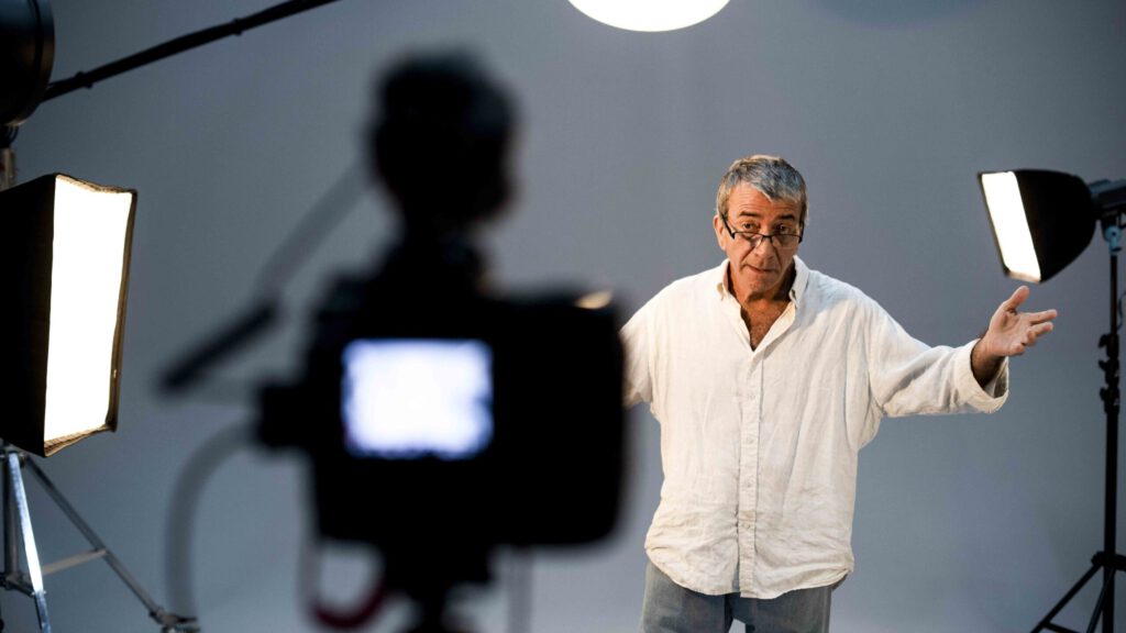 Schauspieler steht vor Kamera und Studioleuchten beim Dreh